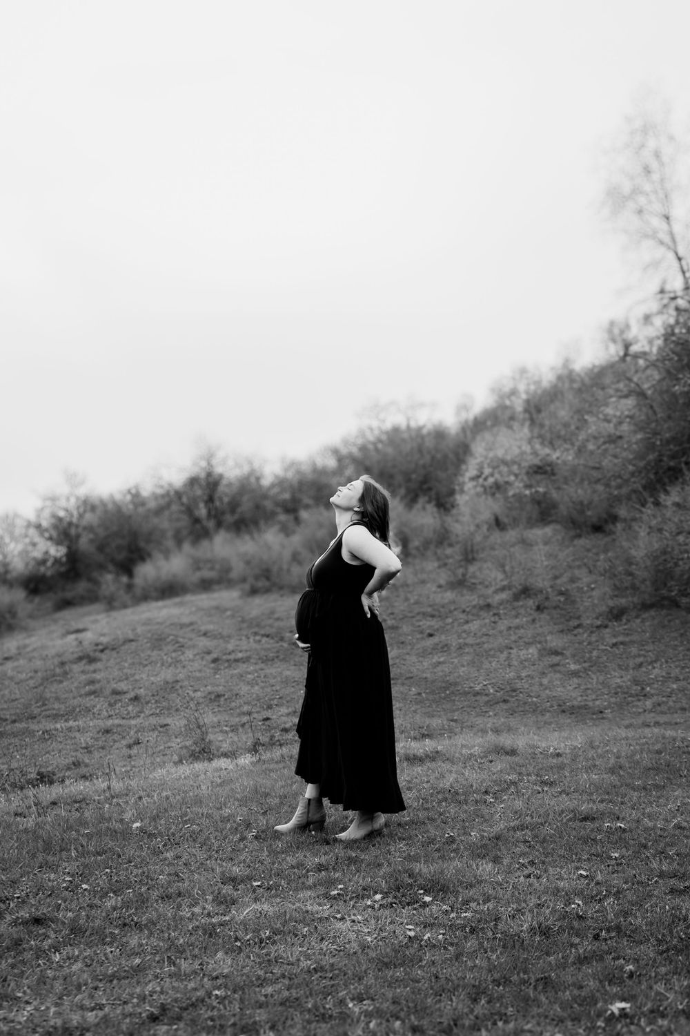 A black and white photo series shows a figure in dark clothing moving across a grassy hillside.
