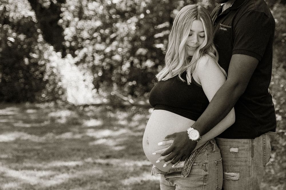 A romantic black and white photo series showing intimate moments between a couple in an outdoor setting.