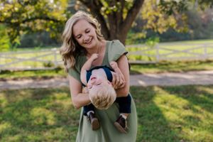 Playful outdoor portrait showing pure joy and laughter in a sun-dappled park.
