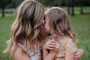 Tender moment shared outdoors in natural lighting during summer.