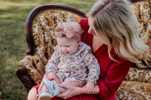 Intimate moment on antique floral sofa during family photoshoot.