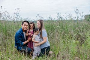Family enjoying quality time together outdoors in a natural meadow setting.