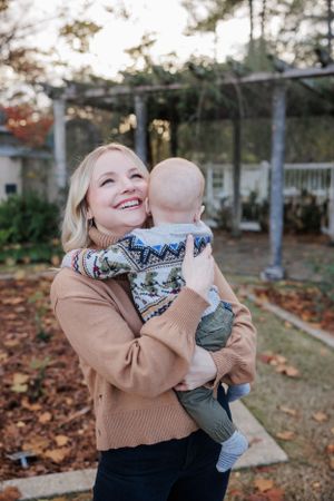 Sweet moment between parent and baby outdoors during fall season.