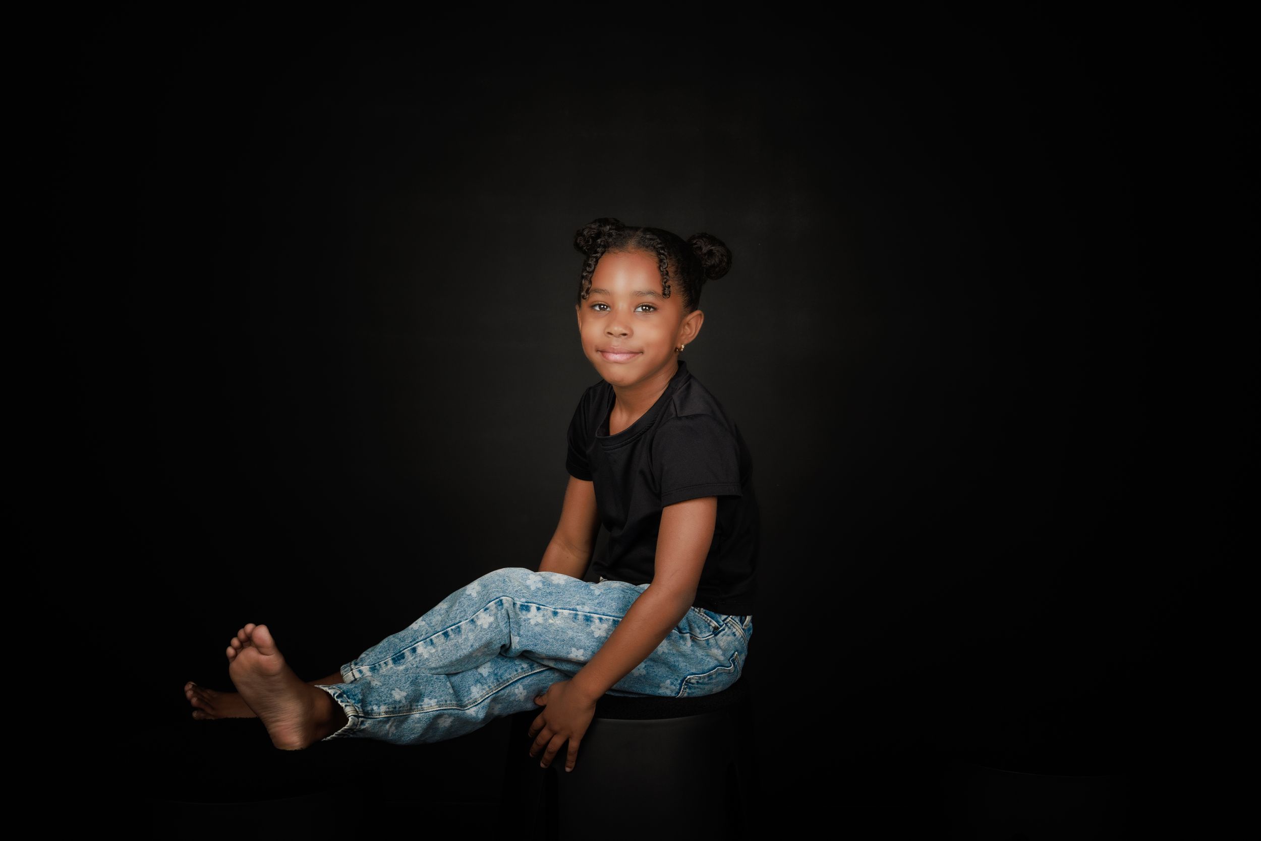 A series of moody studio portraits showing a person in casual attire against a dark background.