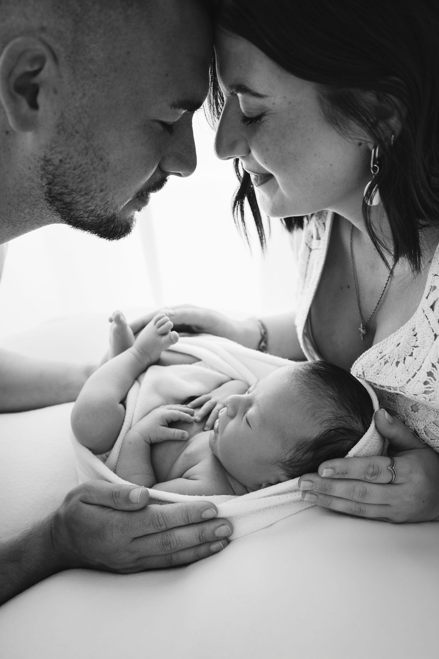 Black and white intimate newborn photography session with parents.