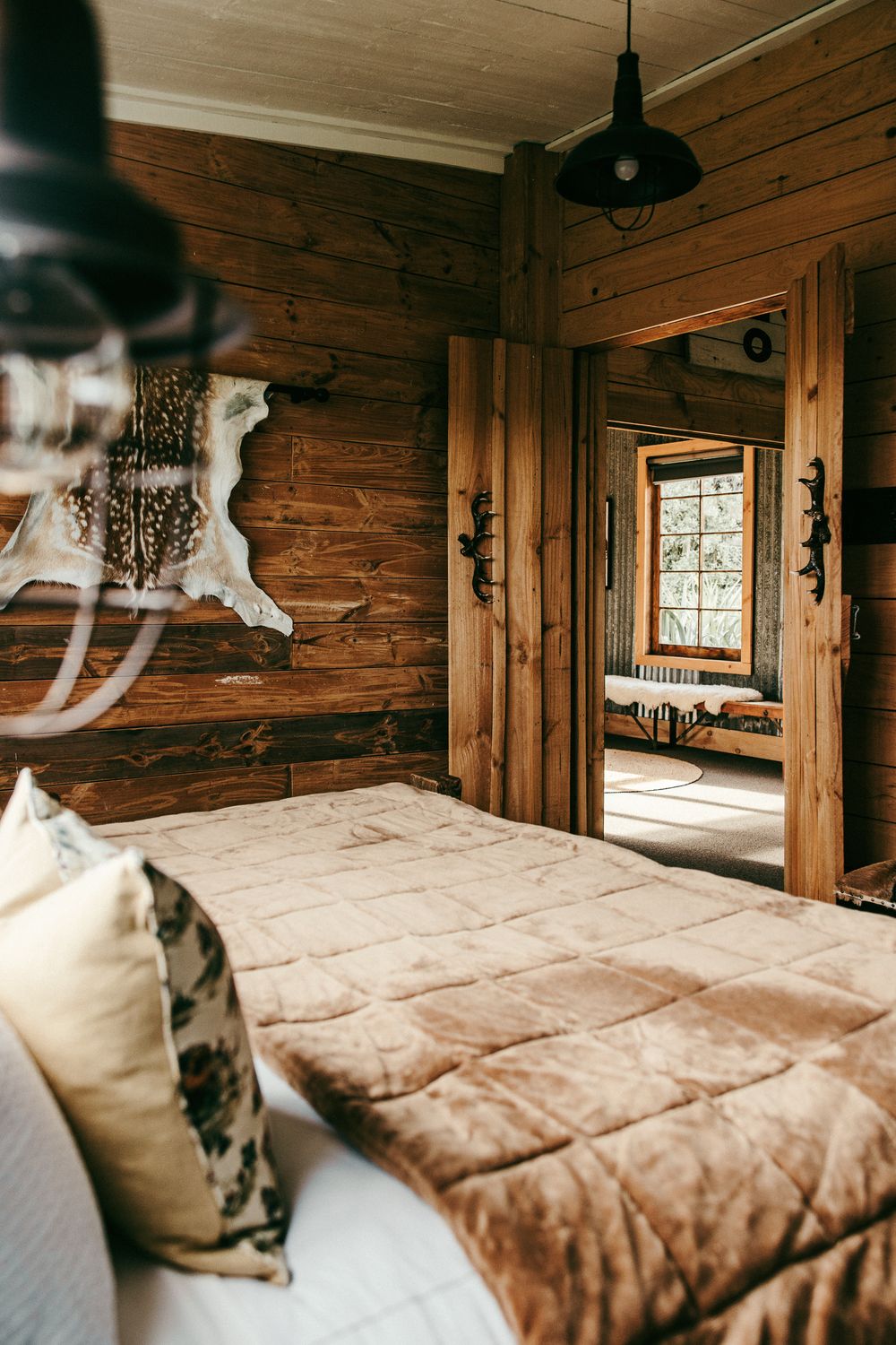 Comfortable bedroom with floral throw pillows and rustic wood beam details.