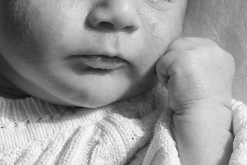 Close-up macro shot of baby's face in black and white.