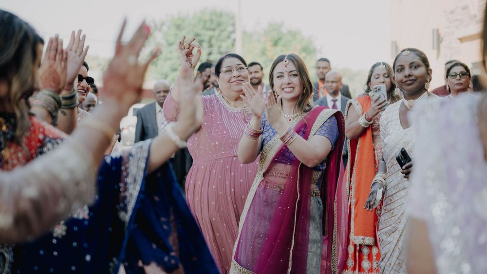 Wedding guests dancing joyfully in vibrant cultural attire at celebration.