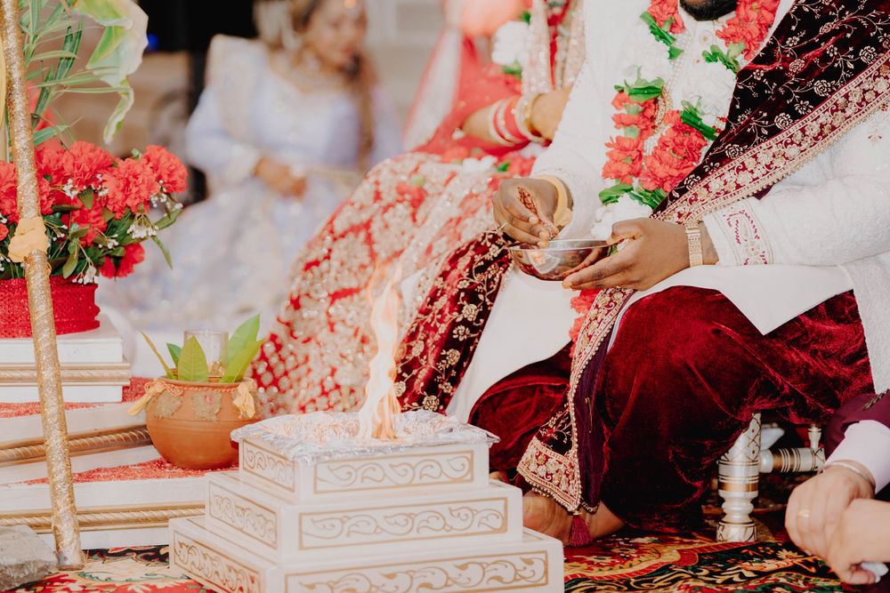 Close-up of traditional Indian wedding ceremony items with red flowers and decorative elements.