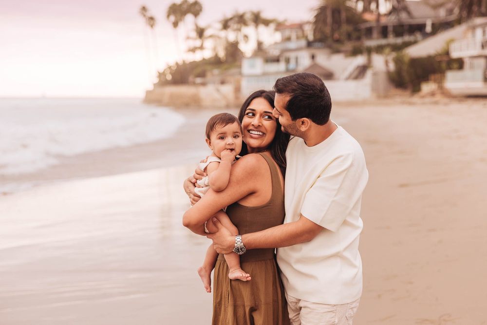 A family enjoys quality time together on a sunny beach at sunset.