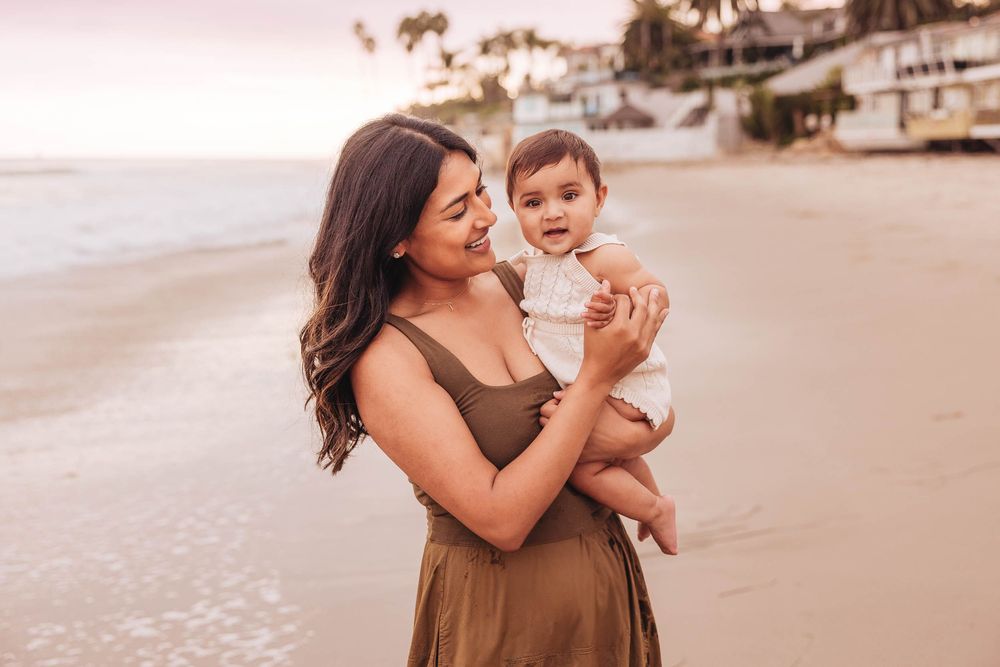 Warm sunset tones illuminate tender family interactions on a sandy beach.