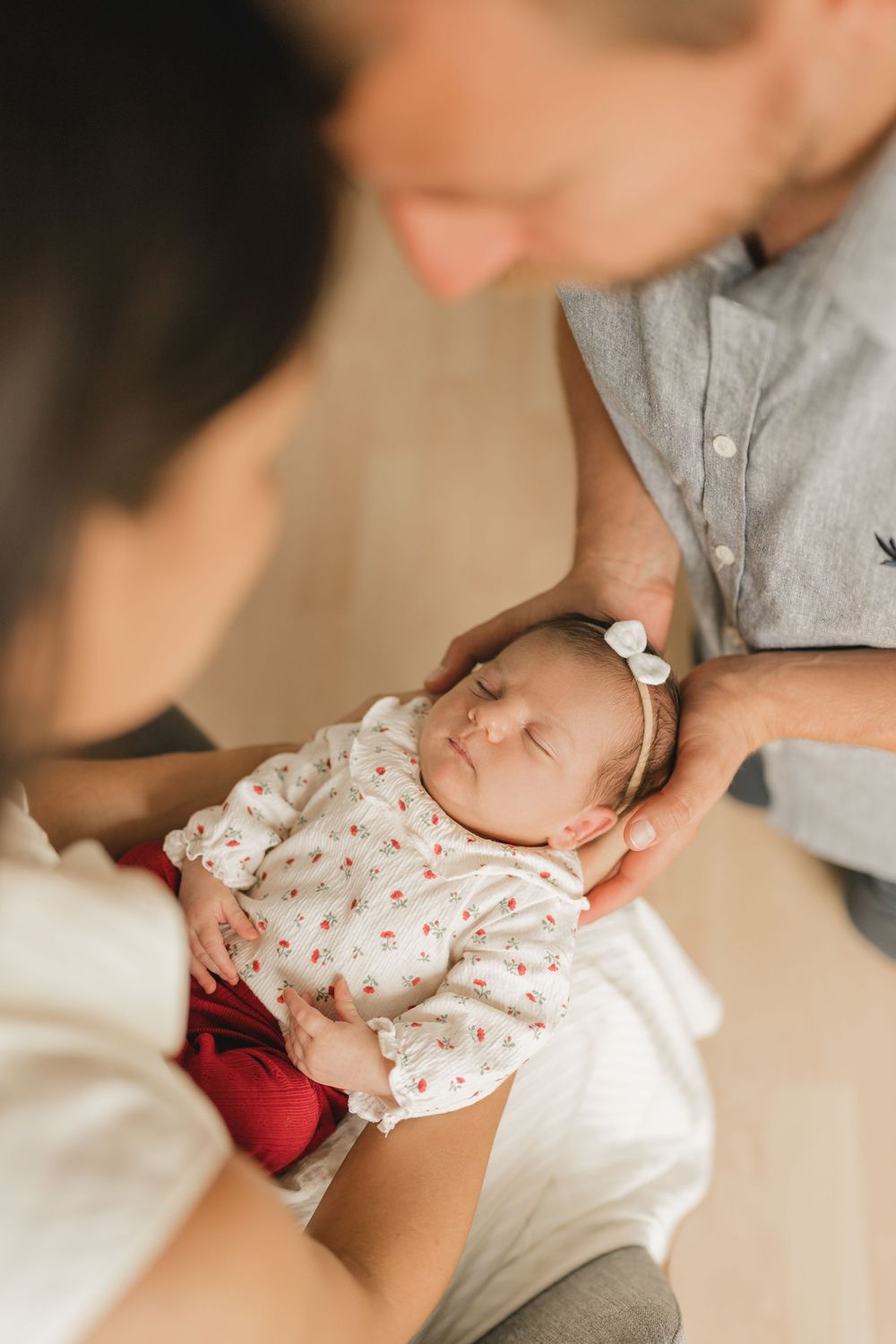 Eltern mit neugeborenen Baby auf dem Arm - Liebevolle Babyfotografie im eigenen Zuhause in Biberach von Ramona Maier