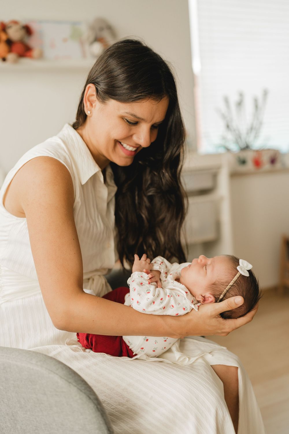 Mama schaut ihr neugeborenes Baby verliebt an - Liebevolle Babyfotografie im eigenen Zuhause in Biberach von Ramona Maier