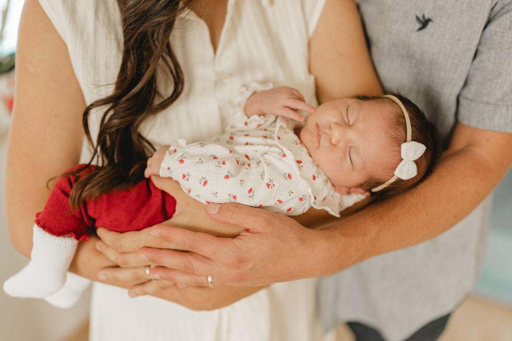 Eltern mit neugeborenen Baby auf dem Arm - Liebevolle Babyfotografie im eigenen Zuhause in Biberach von Ramona Maier