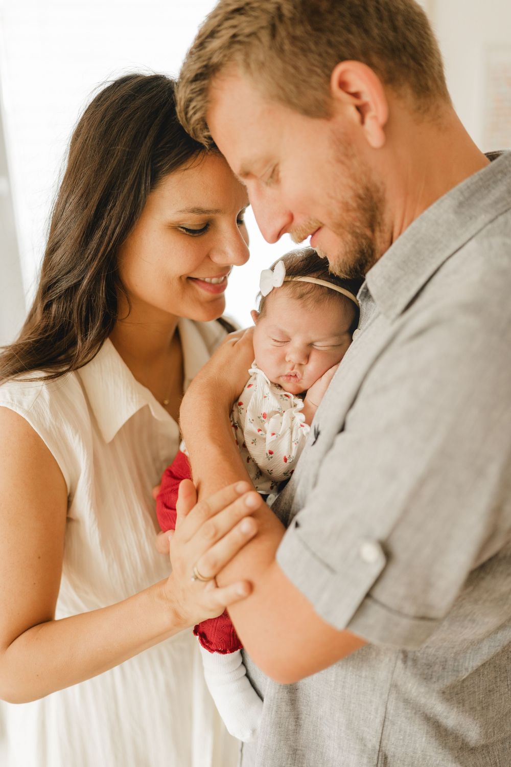 Eltern mit neugeborenen Baby auf dem Arm - Liebevolle Babyfotografie im eigenen Zuhause in Biberach von Ramona Maier