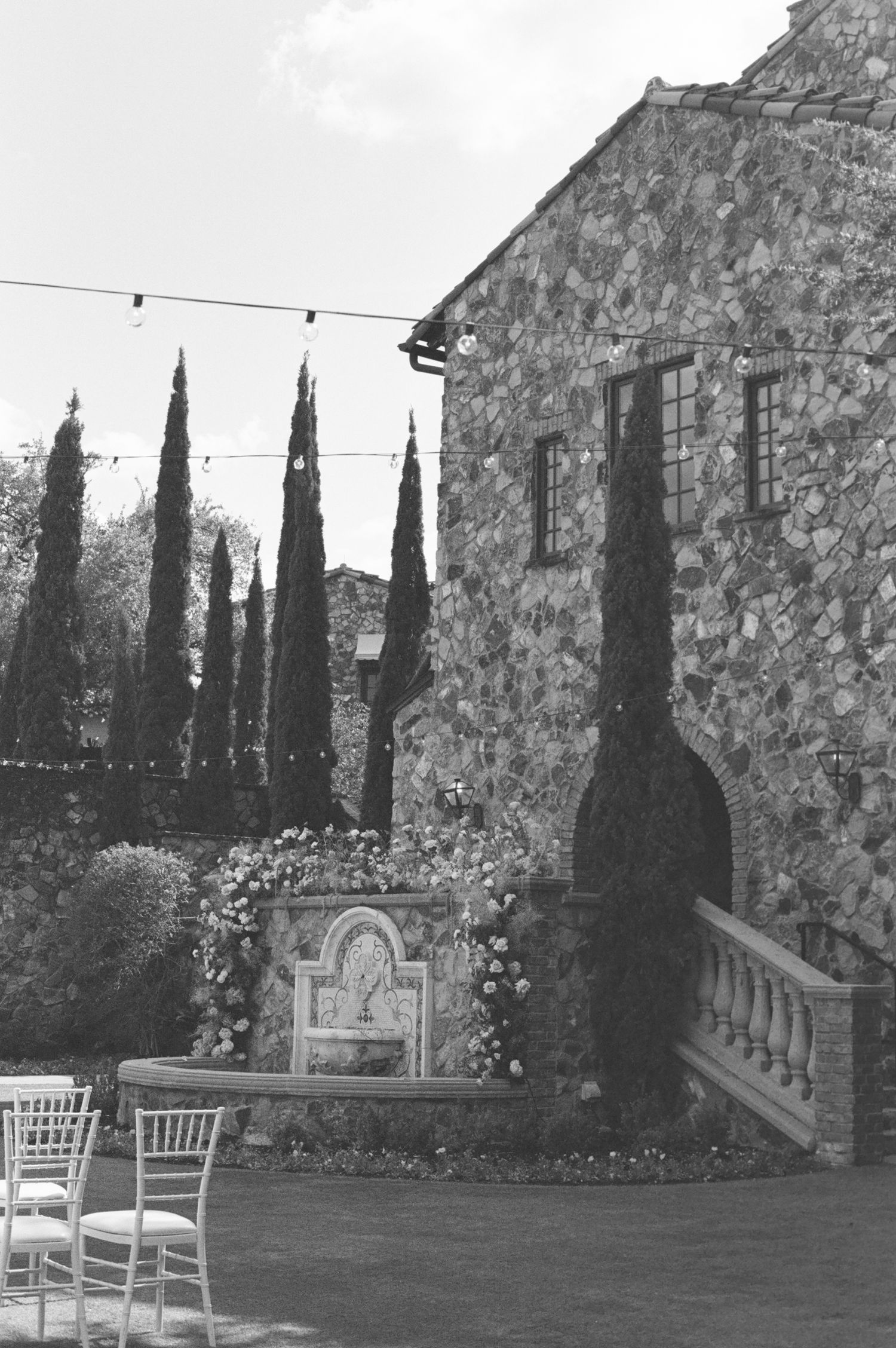 A rustic stone villa wedding venue with cypress trees and string lights in Orlando Florida - Bella Collina