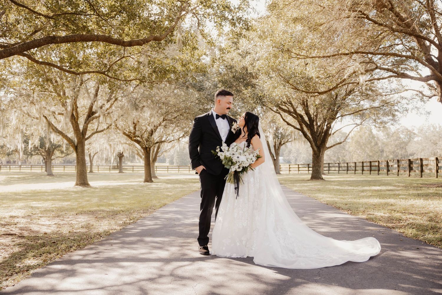 Dreamy wedding photos of a couple walking along a tree-lined path on their special day.