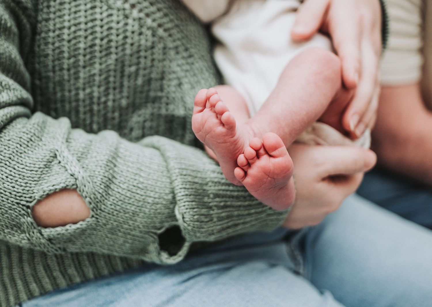 Series of photos showing tiny baby toes being gently touched against a soft sage green knit blanket background.