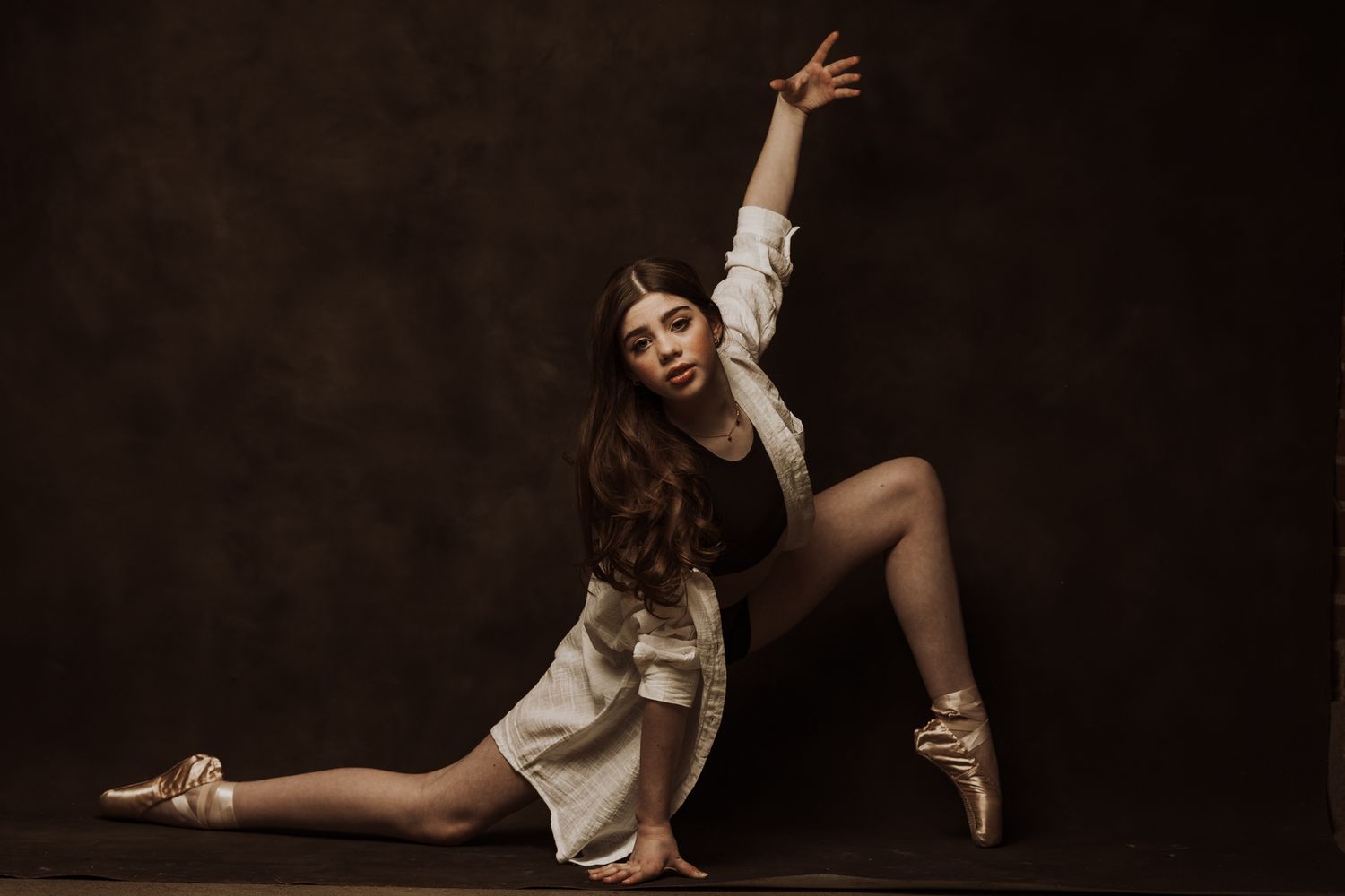 Artistic dance-inspired poses in white outfit against dark background.