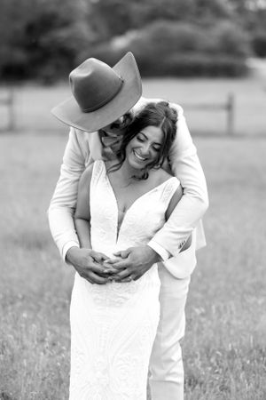 Black and white romantic portrait in rustic countryside setting.