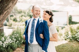 Couple shares joyful moments surrounded by lush gardens during summer outdoor celebration.