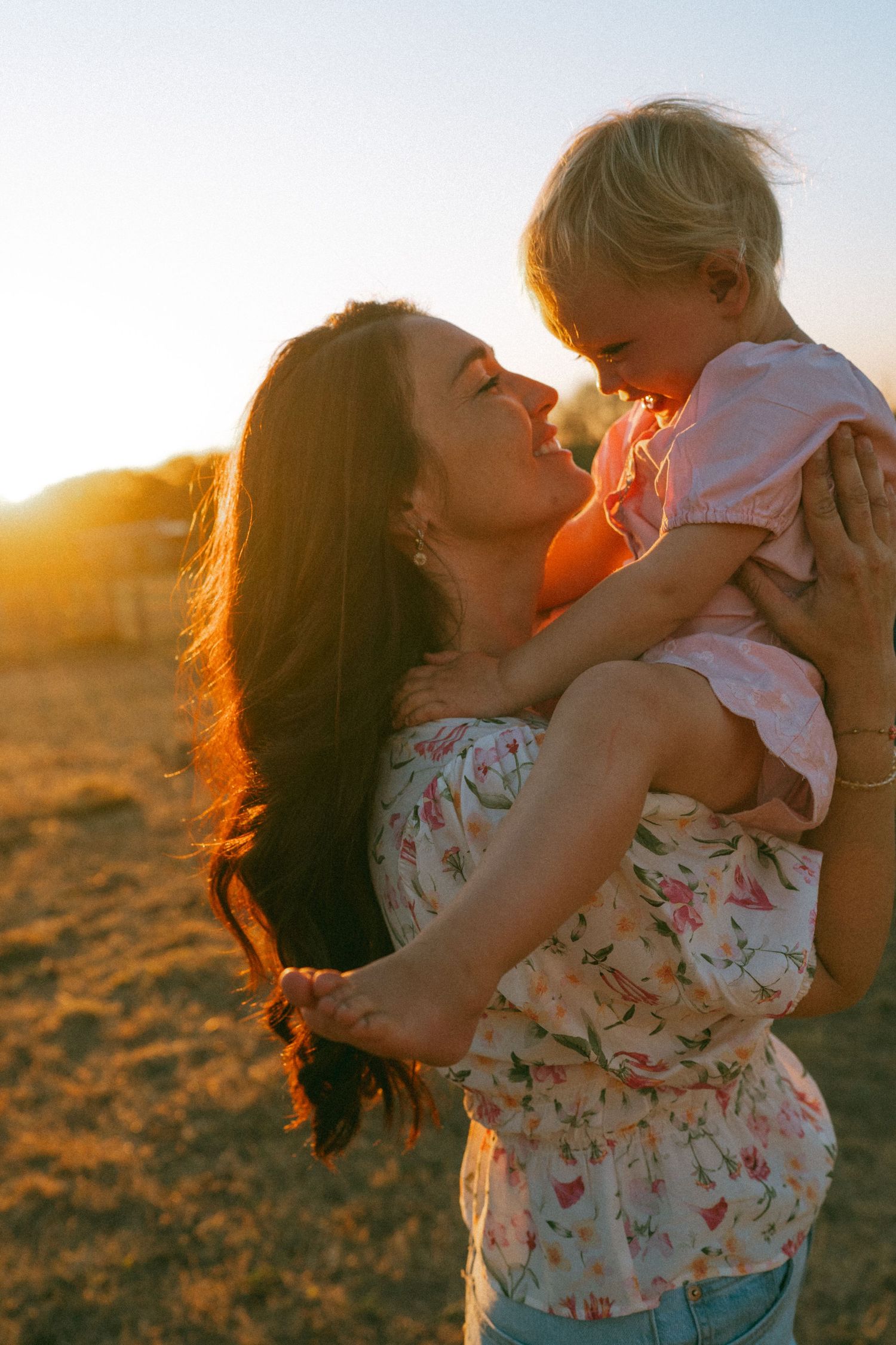 A joyful outdoor scene with floral dress and warm sunset lighting.