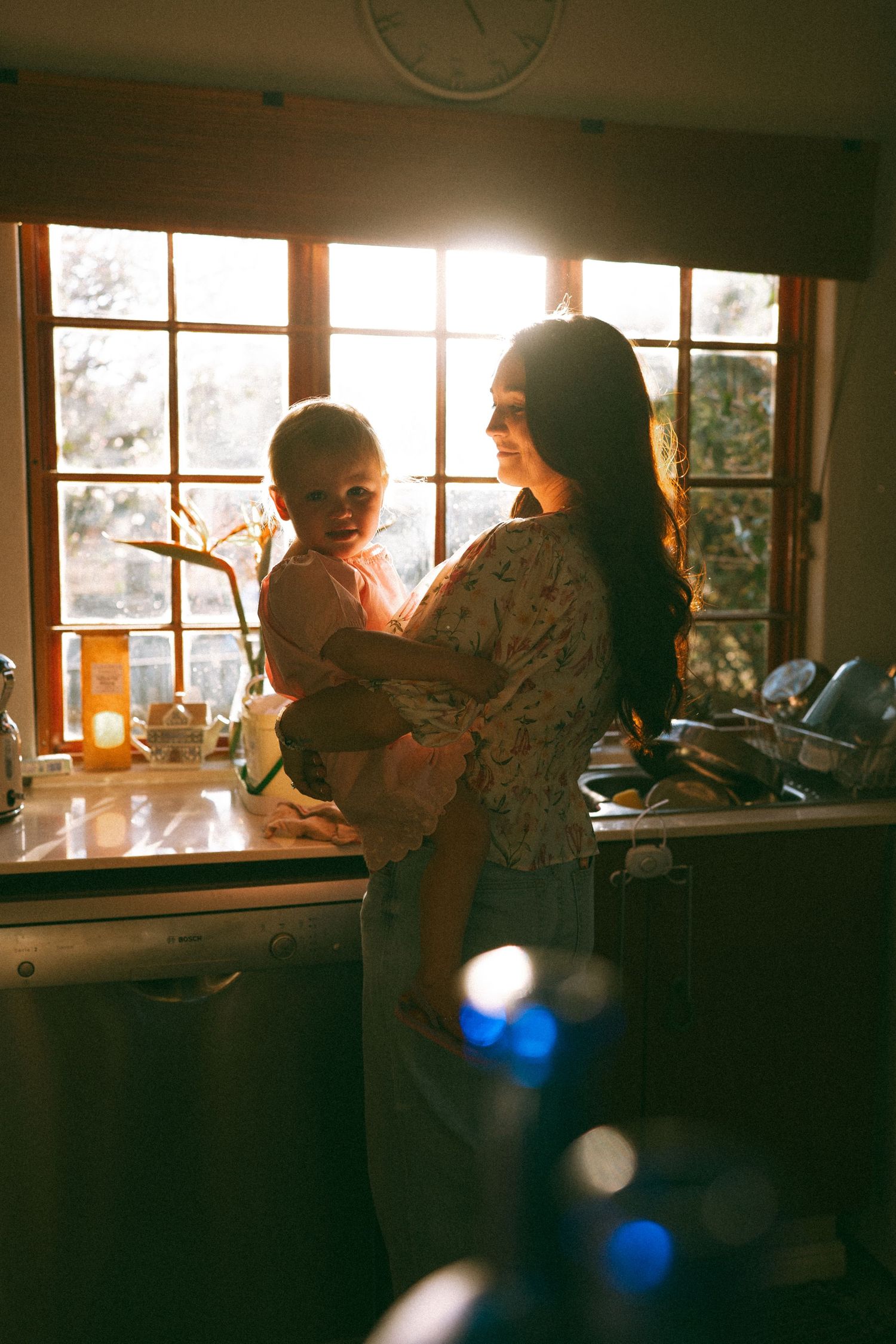 A dimly lit interior scene with sunlight filtering through windows creating atmospheric shadows.