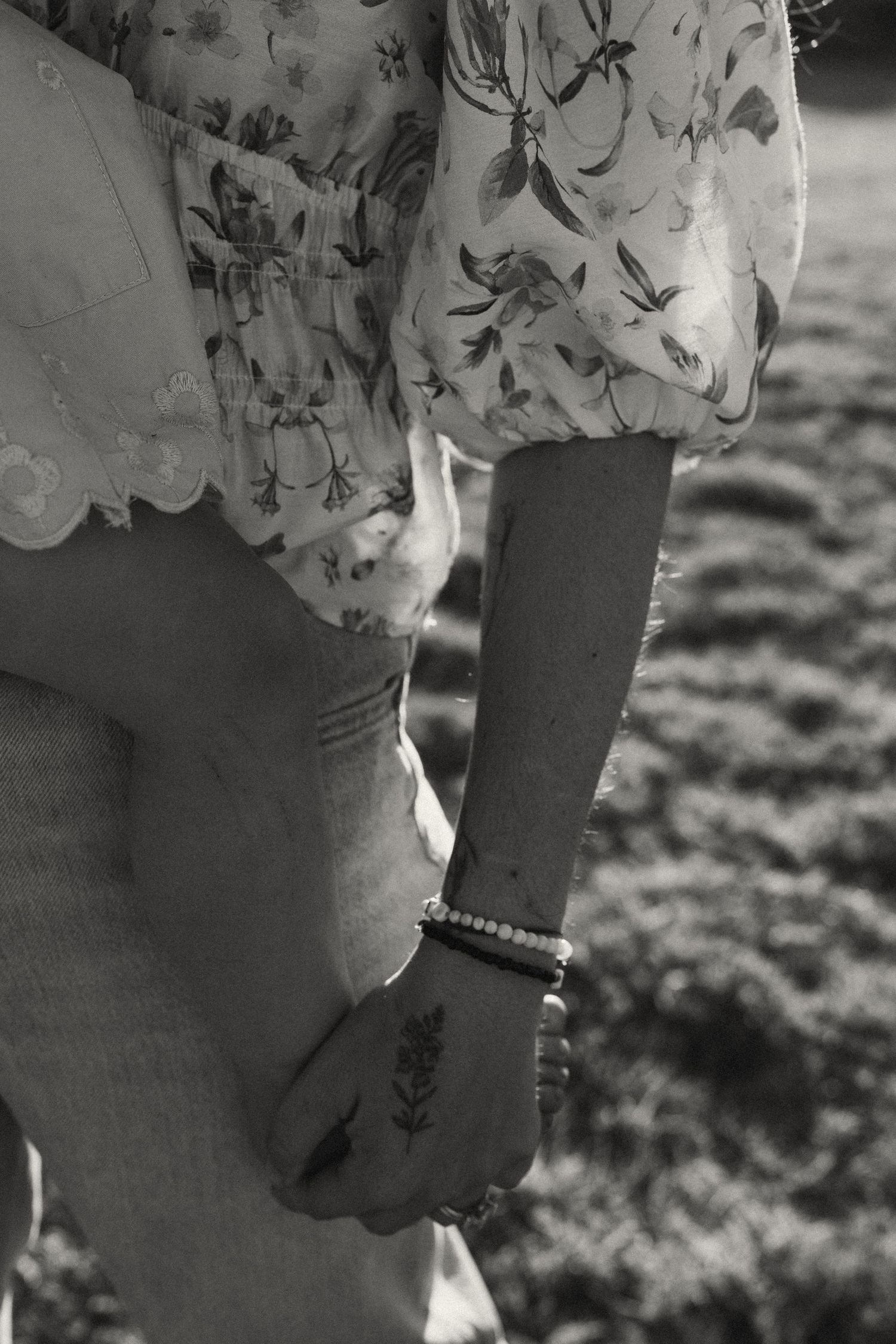 Close-up detail of a floral patterned sleeve and bracelet.