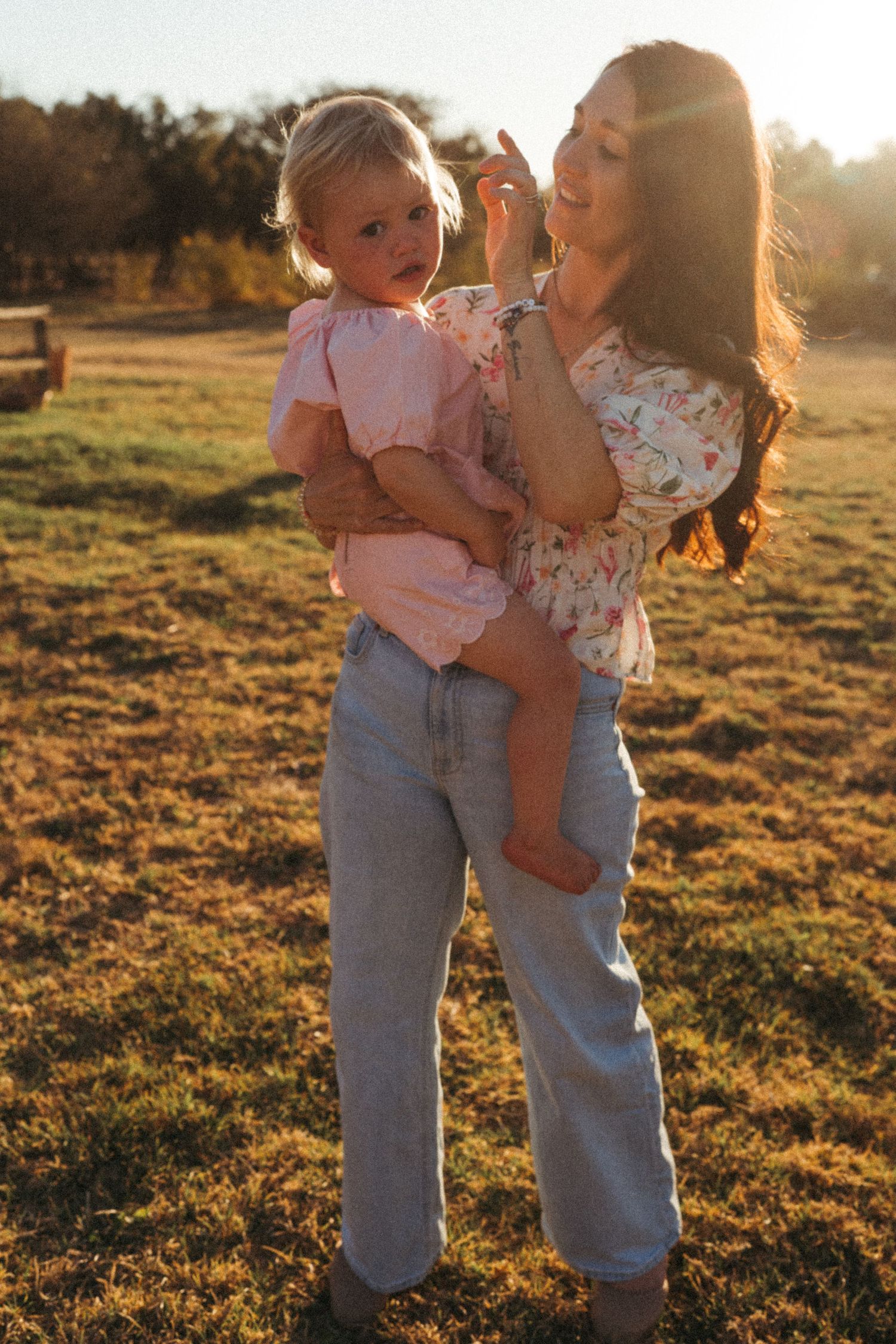 People in denim share an intimate moment in golden sunlight.