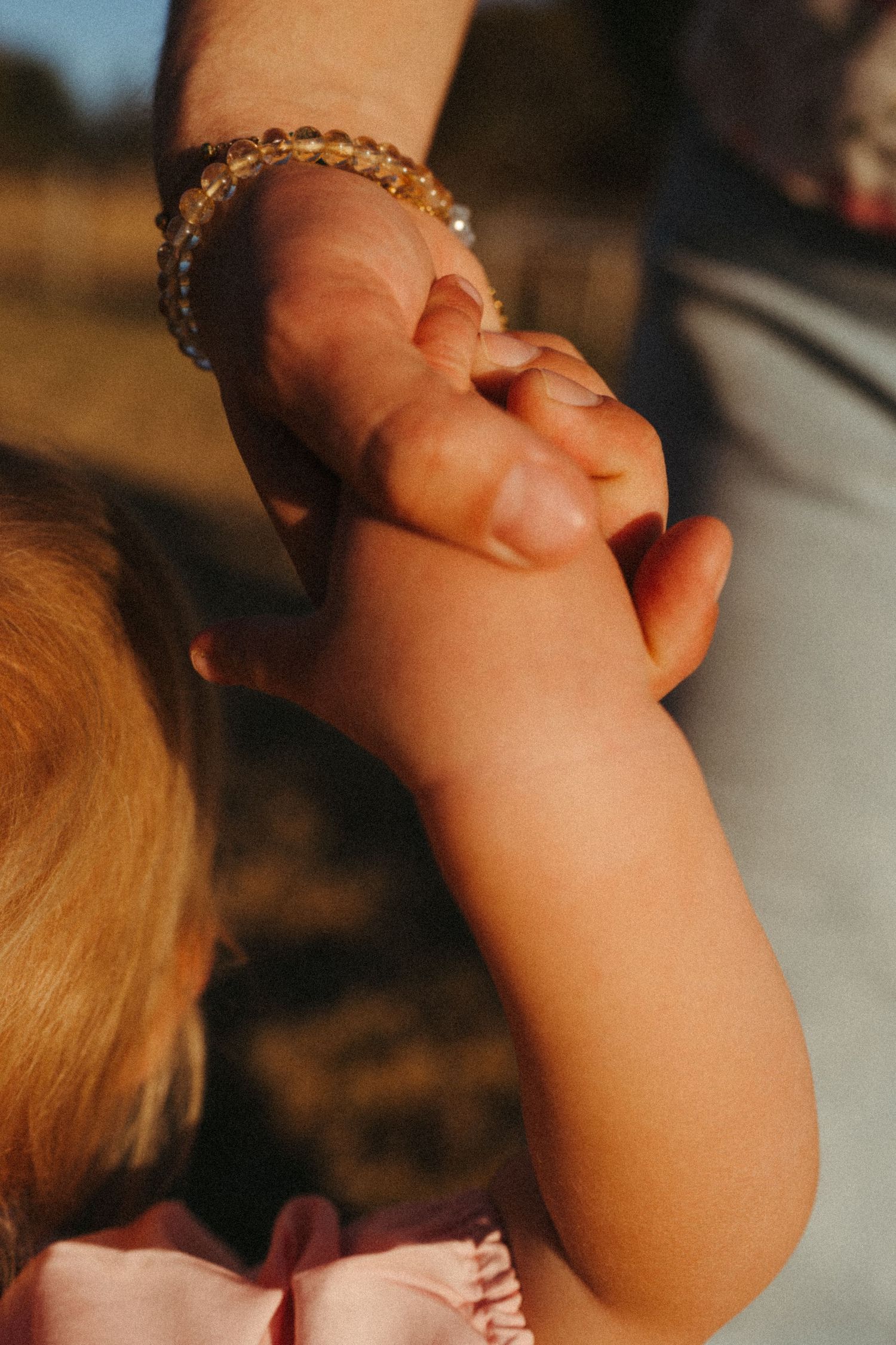 Close-up of small hands reaching out in warm lighting.