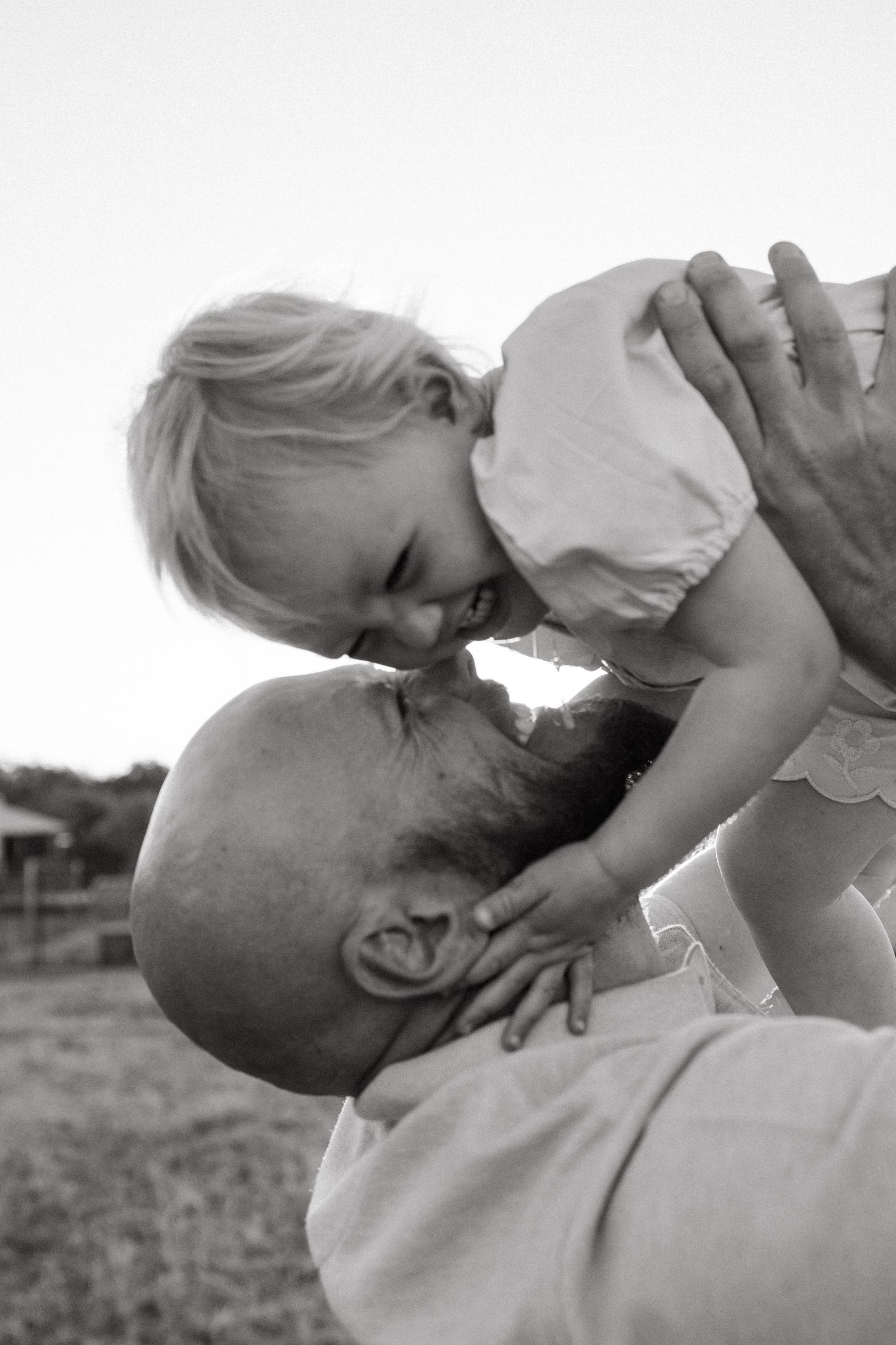 Black and white intimate family moment captured during outdoor photography session.