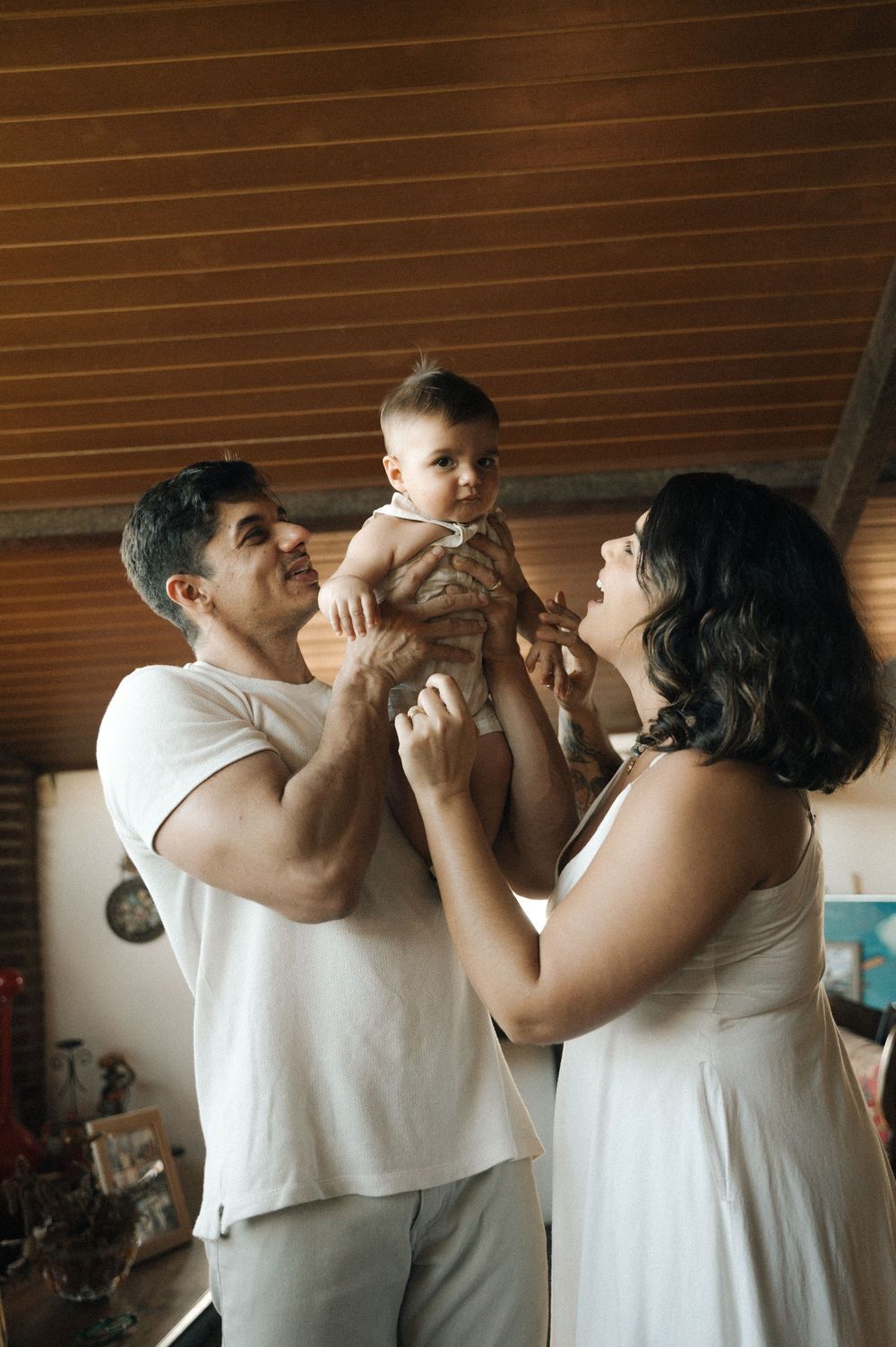 A family sharing a joyful moment together in their home with warm lighting and wooden backdrop.