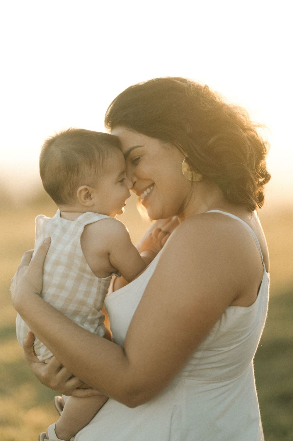 A tender family moment captured in golden sunlight showing parent and child embracing.