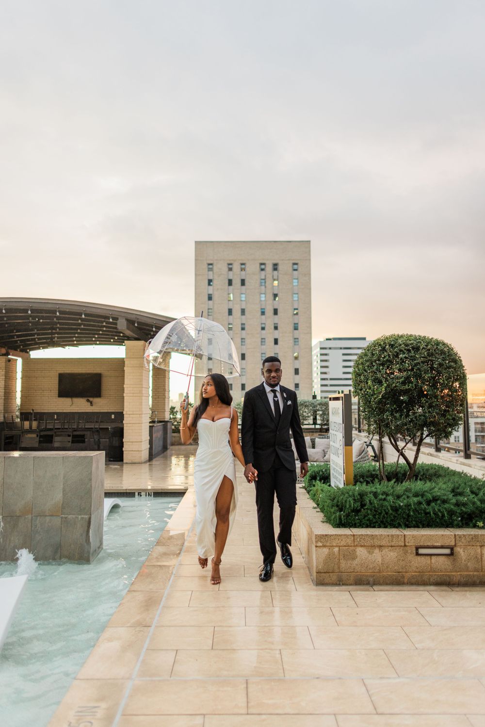 Couple walking together under covered walkway on luxurious rooftop terrace.