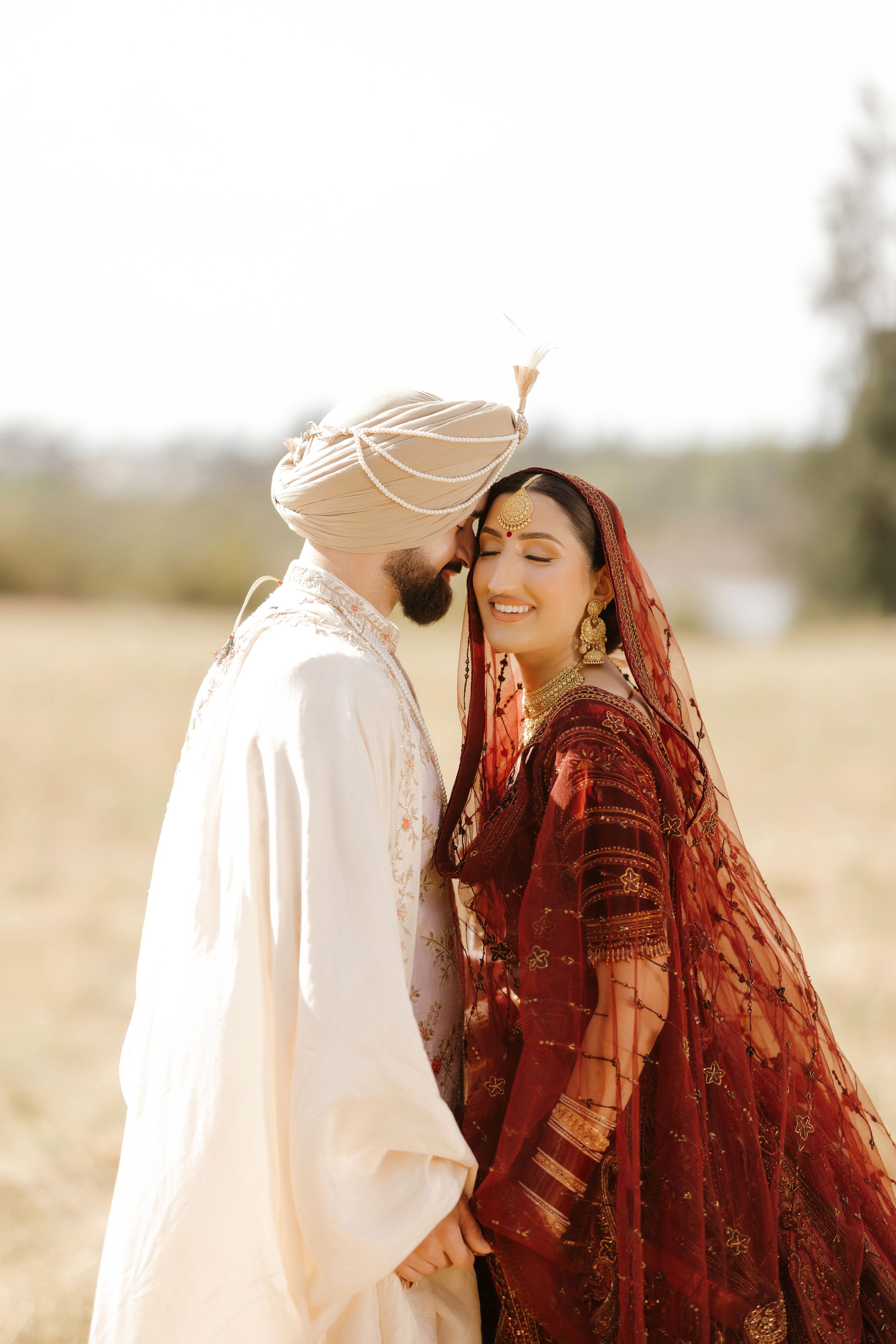 A romantic scene in a sunlit meadow with a couple in traditional dress sharing an intimate moment.