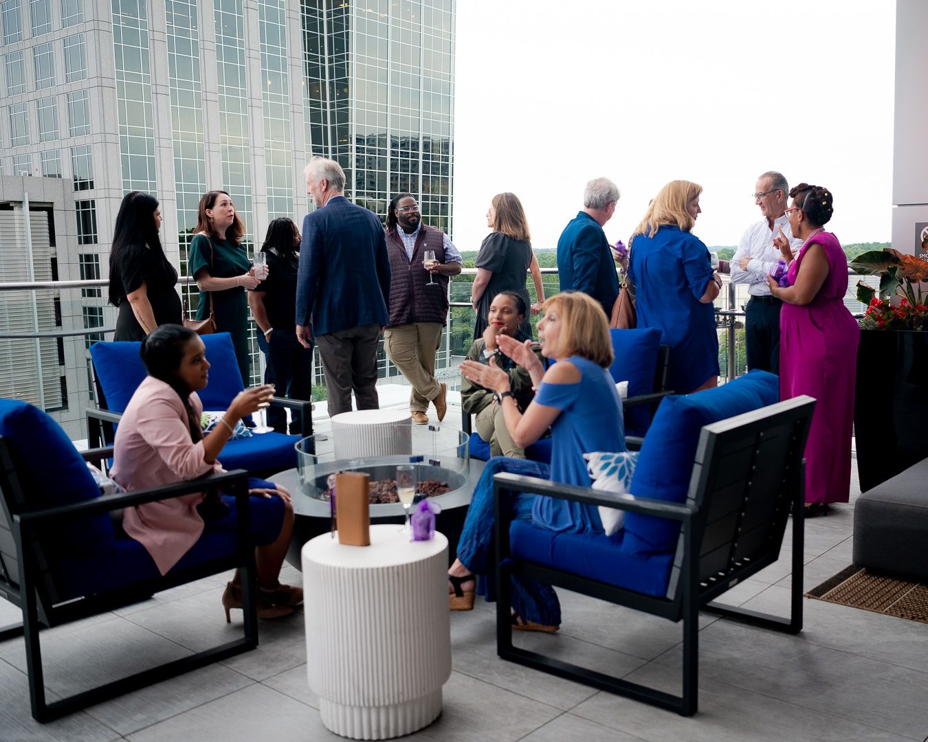 People gather and socialize on an outdoor terrace with city views.