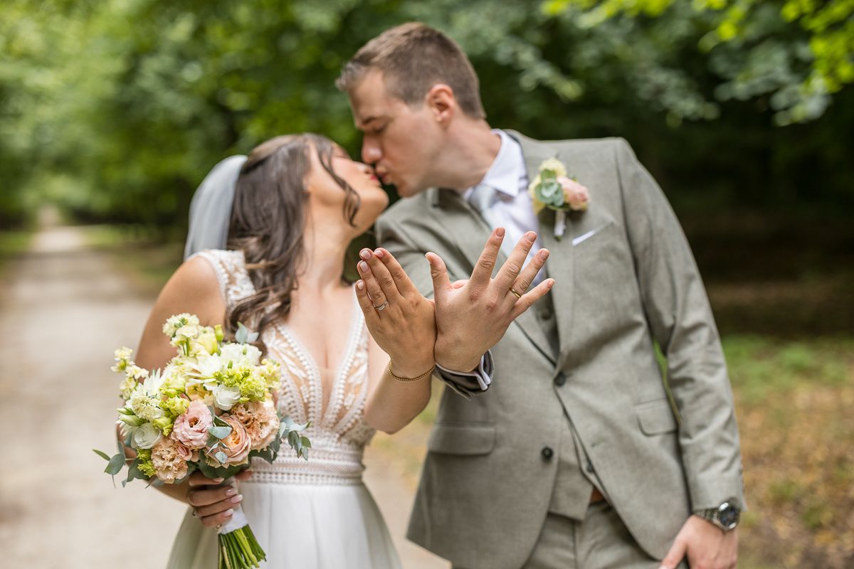 Wedding rings and couple portrait artistically composed with white roses.