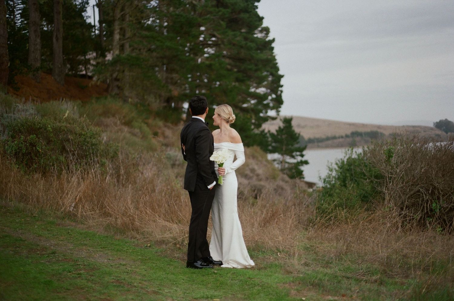 Film wedding portrait of a bride and Indian groom overlooking Tomales Bay in Point Reyes, Northern California with a classic, minimalist