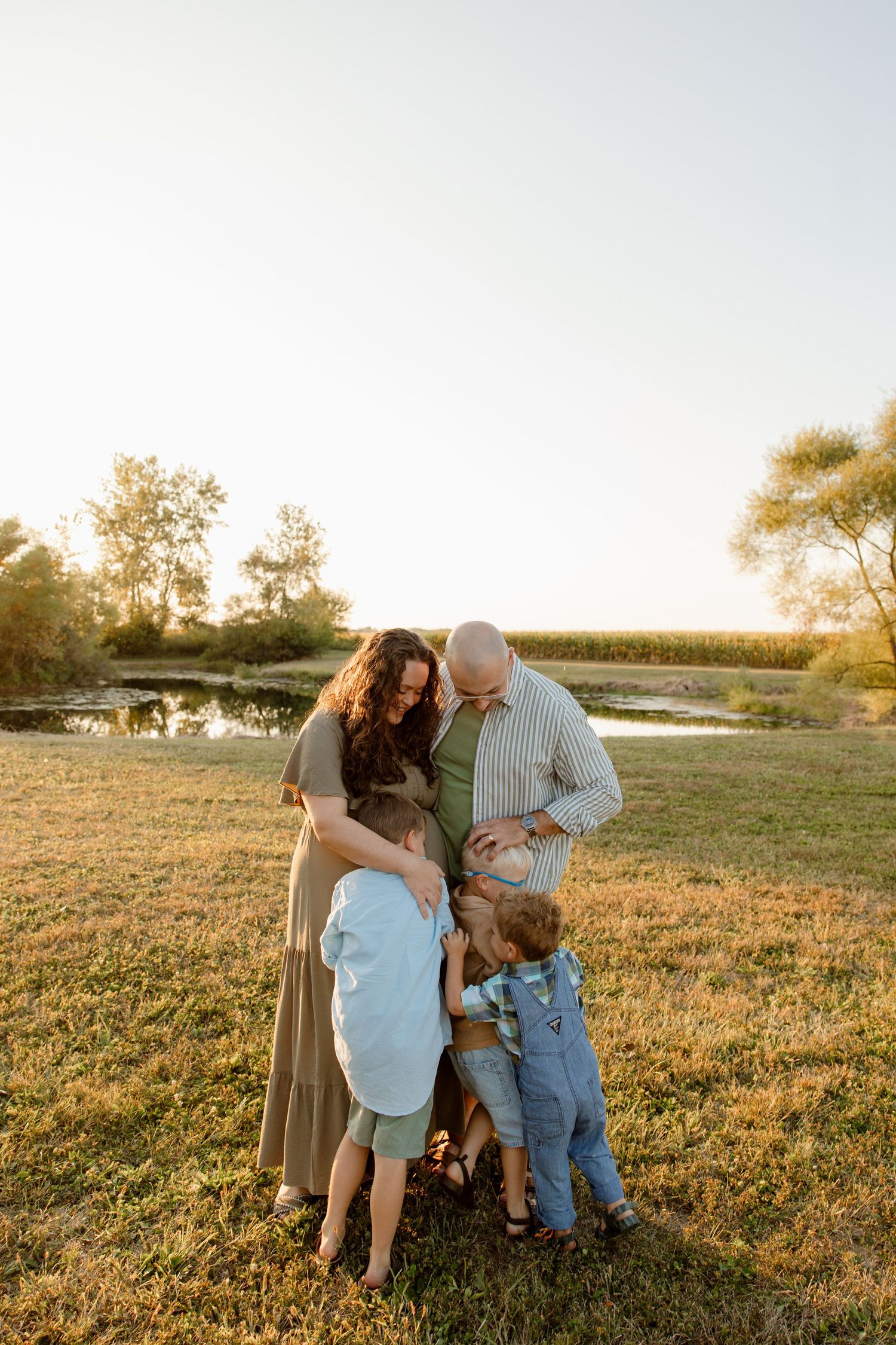 Family gathering in a sunlit field during golden hour.