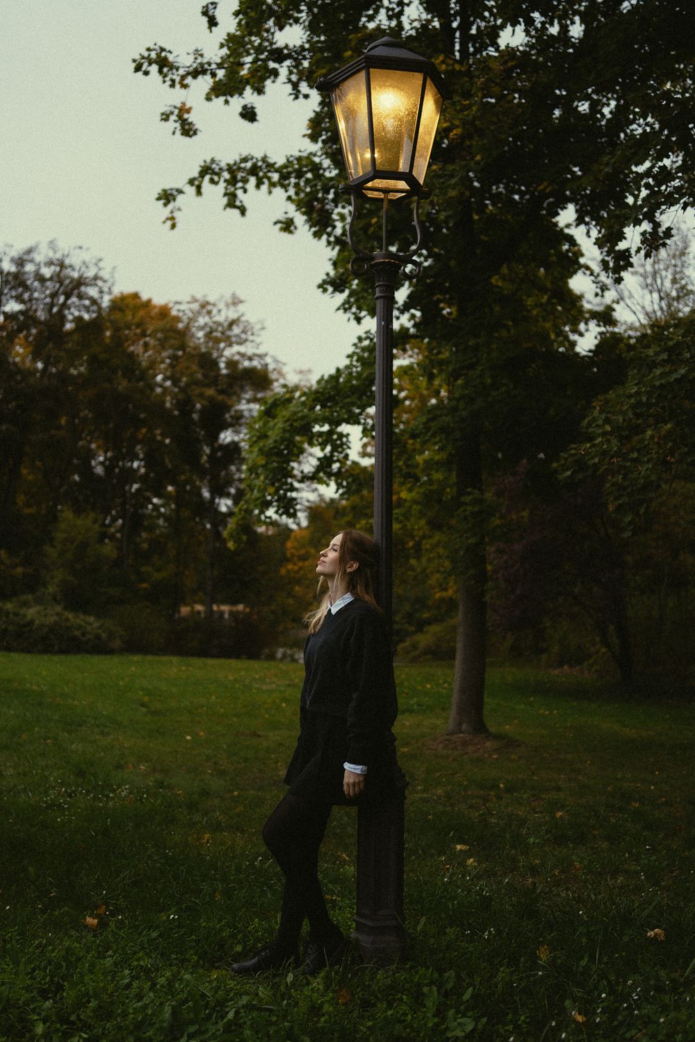 Nostalgisches Fotoshooting einer Frau unter leuchtenden Laterne stehend im Großen Garten Dresden