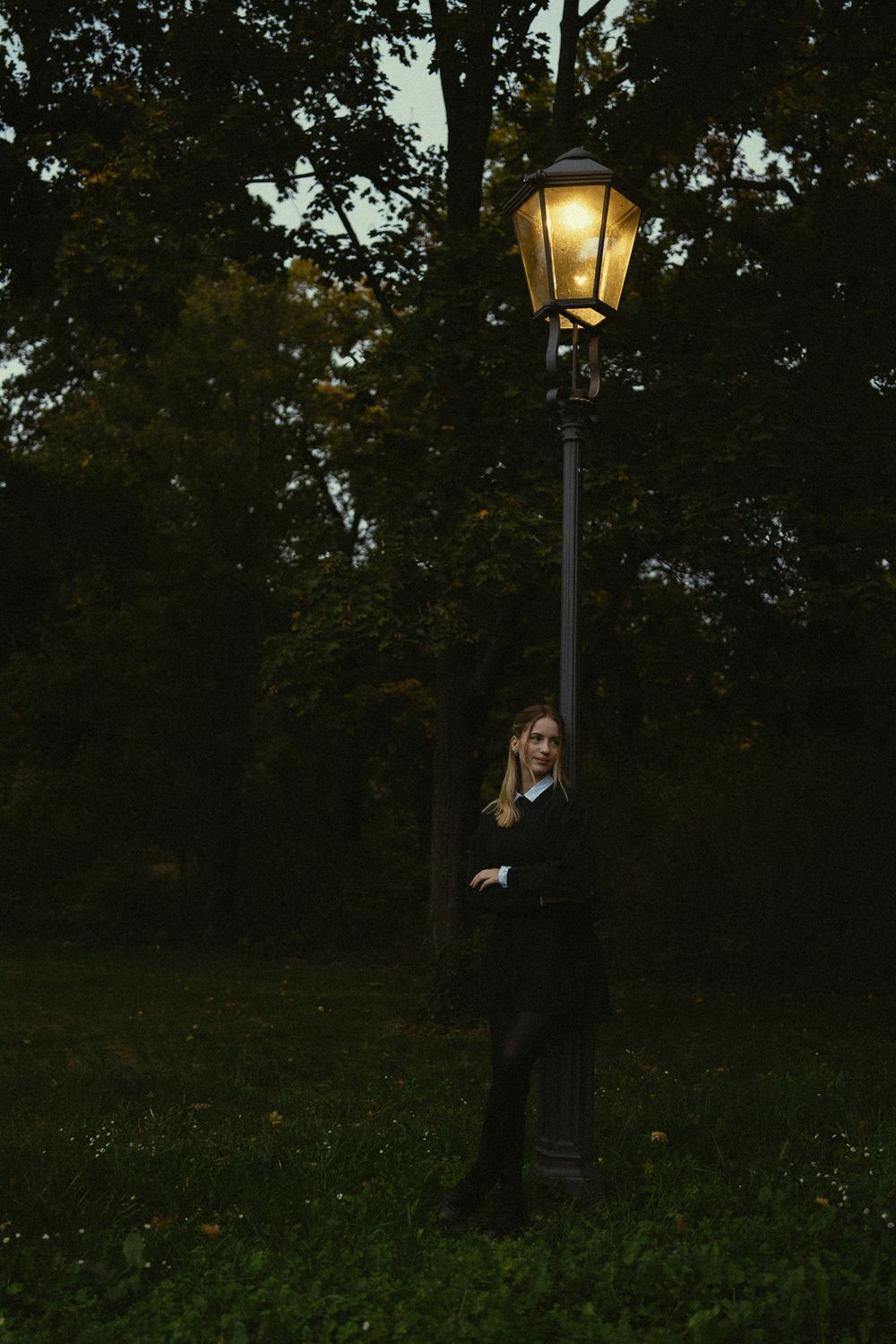 Romantisches Abend Fotoshooting mit Frau und Buch in der Hand unter einer leuchten Laterne stehend - Portrait Park Fotografie Dresden