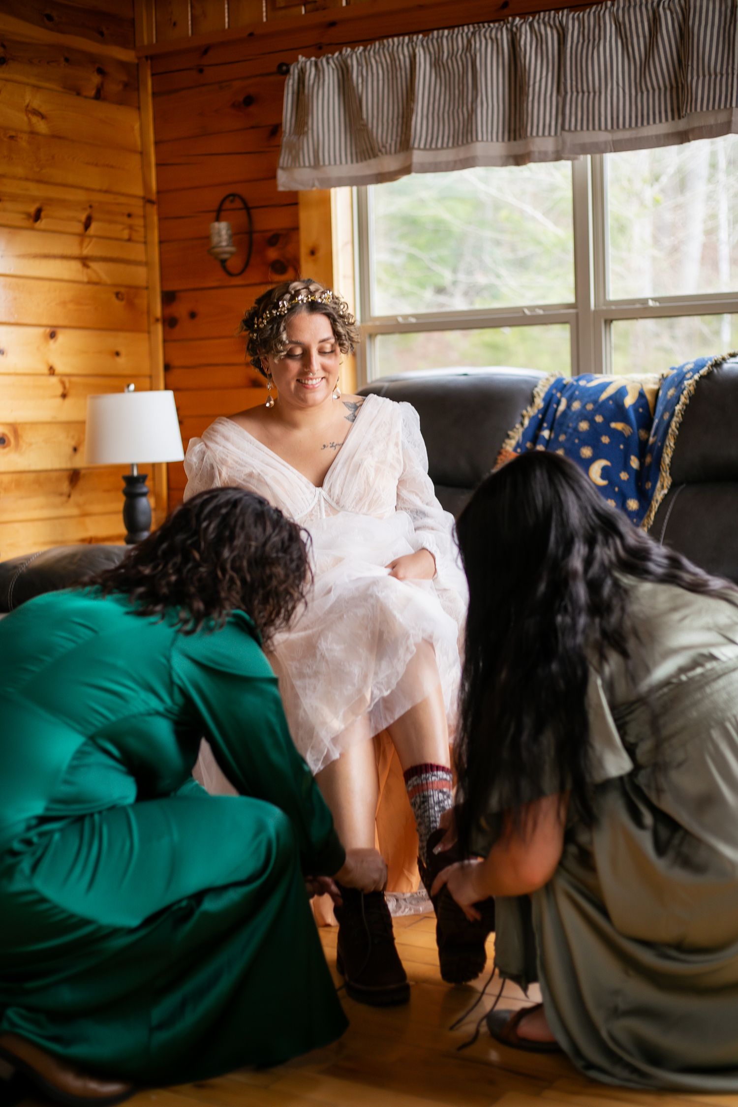 Interior of a rustic cabin with wooden walls and windows, showing casual relaxed moments on comfortable furniture.