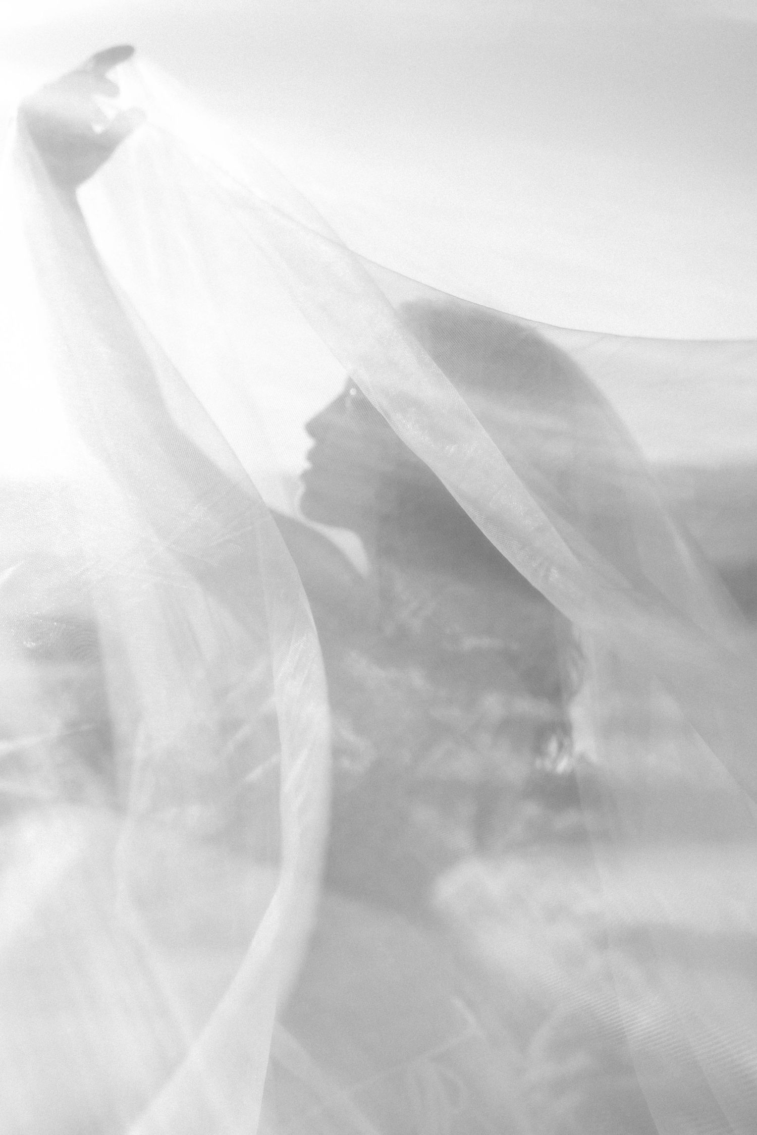Ethereal white fabric flowing in the wind against a soft dreamy background.