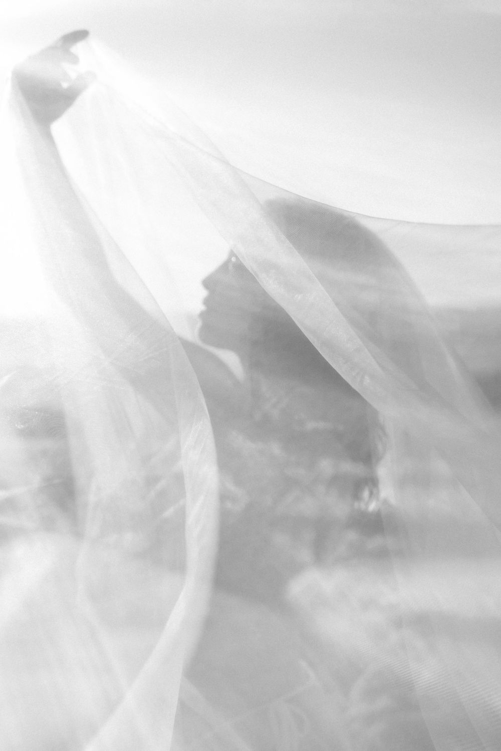 Ethereal white fabric flowing in the wind against a soft dreamy background.