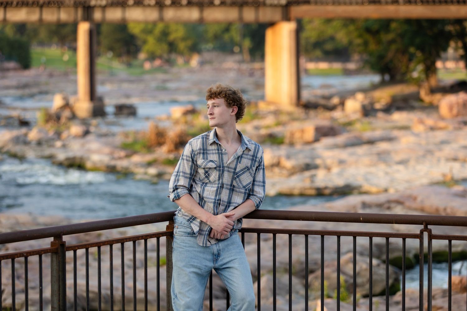 Senior boy photography Sioux Falls, South Dakota. Rowan Tree Photography, unique, high-end senior portraits, boy standing at The Falls.