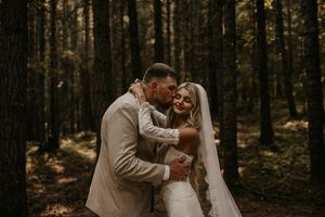 Romantic wedding portraits captured in moody forest setting with natural lighting.
