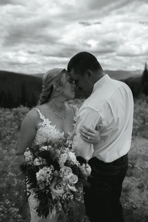 Romantic black and white wedding photo captured against a mountainous backdrop.