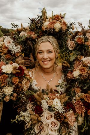 Beautiful autumn-toned wedding bouquets with roses and foliage against a natural backdrop.