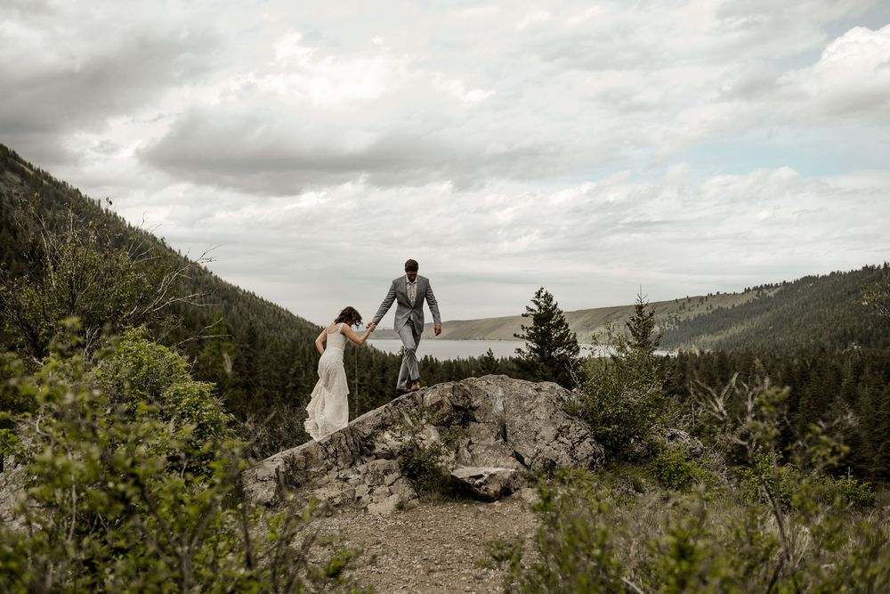 Scenic mountain landscape with couple walking along rocky cliff edge.