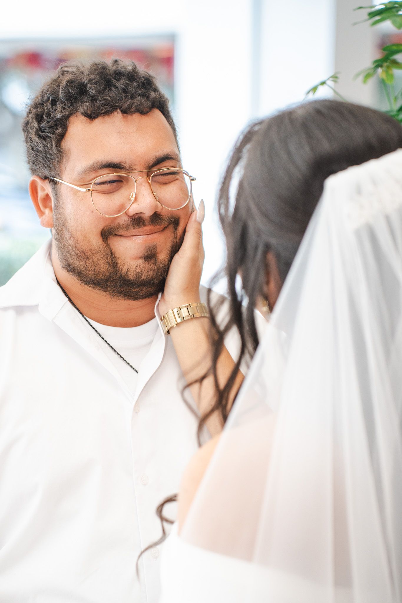 Bride strokes face of groom as they prepare for their wedding